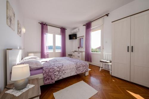a bedroom with a bed and a dresser and windows at Apartments and rooms by the sea Barbat, Rab - 20049 in Rab