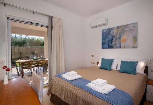a bedroom with a bed with towels on top of it at Meraki Cretan Hospitality in Maleme