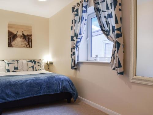 um quarto com uma cama e uma janela em Aquamarine em Scarborough