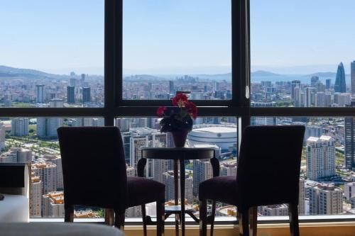 een kamer met 2 stoelen, een tafel en een raam bij Ataşehir's Most Luxurious Top Floor Residence in Istanbul