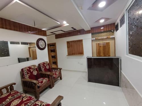a room with two chairs and a flat screen tv at J Beach Stay Rooms in Visakhapatnam