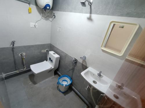 a bathroom with a sink and a toilet and a mirror at J Beach Stay Rooms in Visakhapatnam