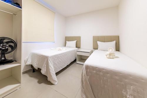 a bedroom with two beds and a teddy bear at Apto Póximo a Praia de Barra de São Miguel - Destino BSM 106 A in Barra de São Miguel