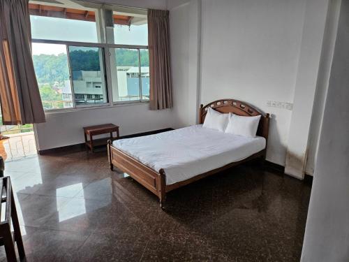 ein Schlafzimmer mit einem Bett in einem Zimmer mit einem Fenster in der Unterkunft Oyado Marufuku in Kandy