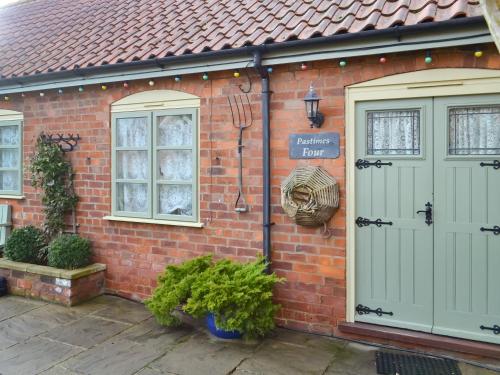 a brick house with two doors and a sign on it at Pastimes Cottage - Uk46263 in Tetney