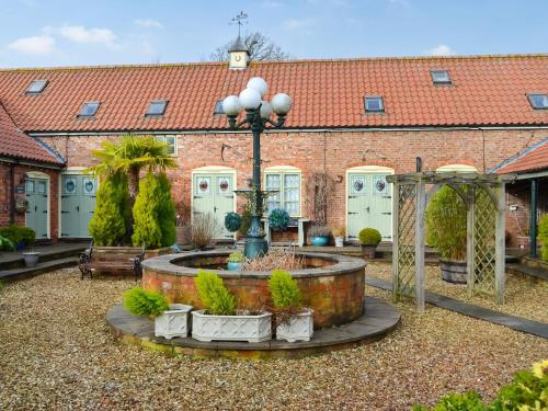 a brick building with a courtyard with a fountain at Pastimes Cottage - Uk46263 in Tetney