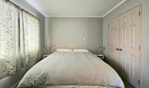 ein Schlafzimmer mit einem großen Bett in einem Zimmer in der Unterkunft Cozy Private Villa in Oropi in Oropi