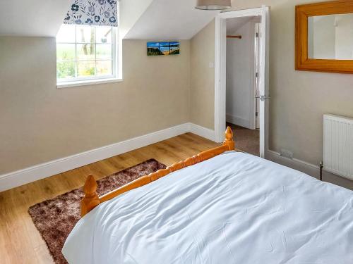 1 dormitorio con 1 cama en una habitación con ventana en The Lodge At Owstwick Hall 