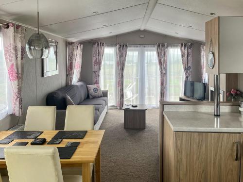a caravan living room with a table and a couch at Woodend Caravan in Lairg