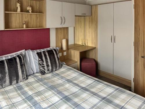 sypialnia z łóżkiem, biurkiem i szafkami w obiekcie Woodend Caravan w mieście Lairg