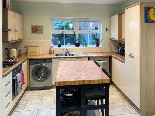 a kitchen with a sink and a washing machine at Melrose Walk in Tewkesbury