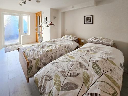 a bedroom with two beds and a window at Estuary Retreat in Llanelli