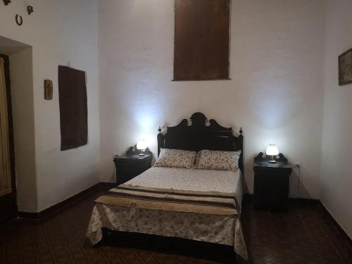 a bedroom with a bed with two nightstands and two lamps at Finca San Francisco y San Javier (ex Finca los tres changos) in Salta