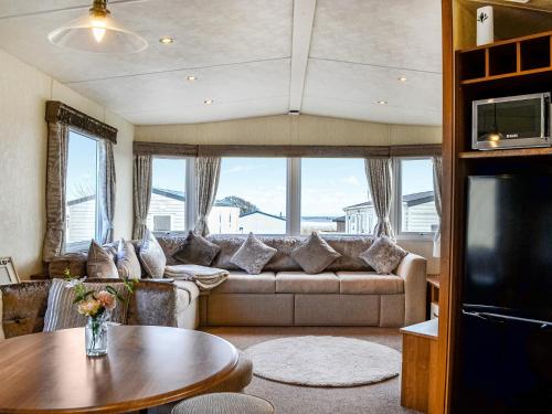 a living room with a couch and a table at Kadelin Cove in Mainsriddle