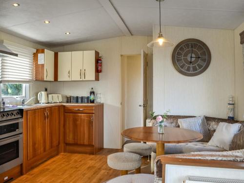 a kitchen and a living room with a table at Kadelin Cove in Mainsriddle