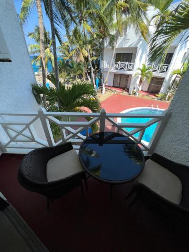 een balkon met stoelen, een tafel en een zwembad bij Ocho Rios Oasis in St Mary