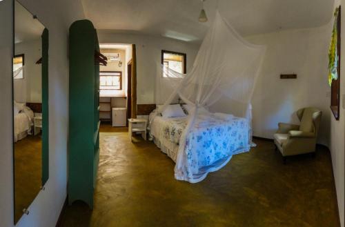 um quarto com uma cama e uma rede mosquiteira em Pousada Aldeia na Ilha de Boipeba