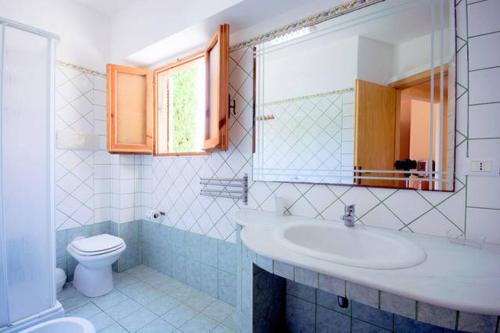 bagno con lavandino, servizi igienici e specchio di Residence Villaggio Smedile a Capo Vaticano