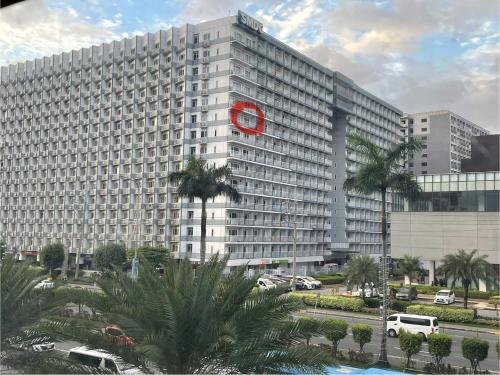 un gran edificio blanco con un reloj rojo. en Shell Residences by Amonbrey Suite nr airport en Manila