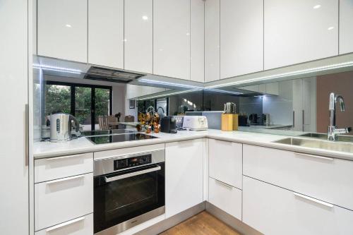墨尔本Sophisticated art deco in the heart of Toorak的白色的厨房配有白色橱柜和电器