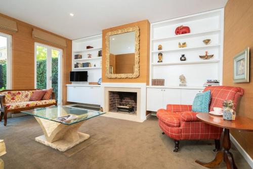 a living room with a fireplace and a mirror at Sophisticated art deco in the heart of Toorak in Melbourne