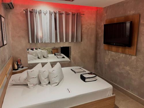 a room with two beds and a flat screen tv at Cassino Motel 1 in Santo André