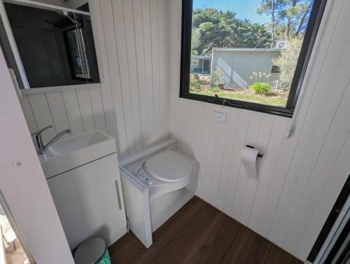 a small bathroom with a toilet and a window at Tiny House 14 at Grampians Edge in Dadswells Bridge
