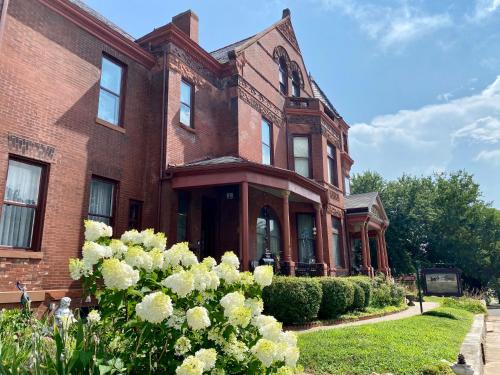 an old brick building with flowers in front of it at Vineyard Mansion B&B in Saint Joseph
