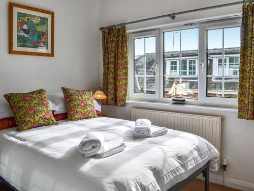 - une chambre avec un lit blanc et des serviettes dans l'établissement The Coach House, à York