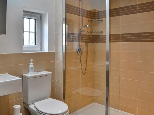La salle de bains est pourvue d'une douche, de toilettes et d'un lavabo. dans l'établissement The Coach House, à York