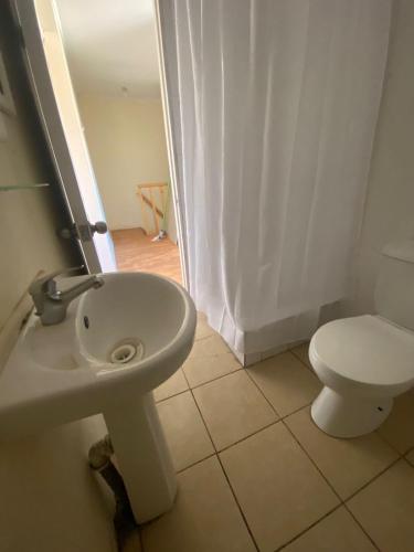 a bathroom with a toilet and a sink at Apartamento en segundo piso, barrio muy tranquilo para descansar en Chillán Viejo in Chillán Viejo