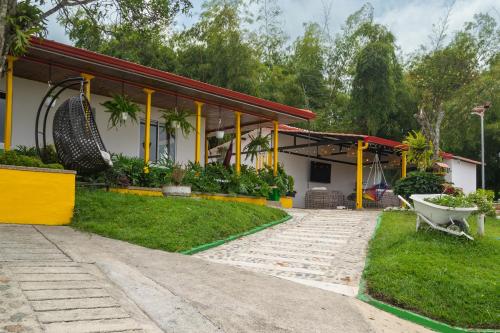 a house with a wheelbarrow in front of it at Alto Bonito Campestre in Circasia