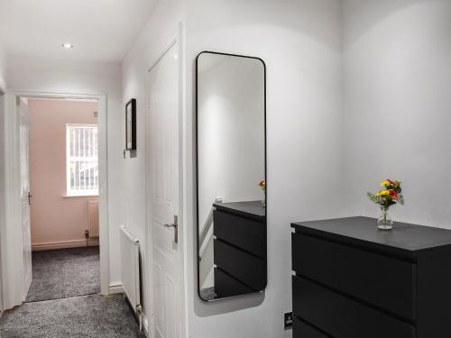 a bathroom with a black dresser and a mirror at West Street House in Southport