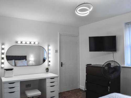 a bedroom with a mirror and a dresser and a desk at West Street House in Southport