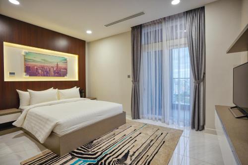 um quarto com uma cama grande e uma janela grande em URBAN PALACE em Phnom Penh