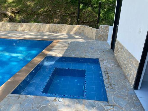 een zwembad met blauwe tegels aan de zijkant van een huis bij Finca en San Jerónimo, todas las comodidades in San Jerónimo