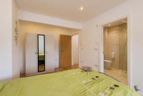 sypialnia z zielonym łóżkiem i łazienką w obiekcie Jubilee Cottage - Cwc75016 w mieście Saint Breward