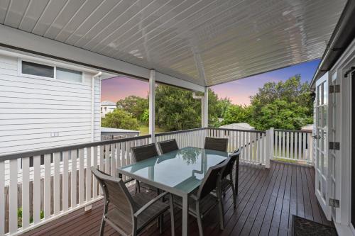 a patio with a table and chairs on a deck at Spacious and Charming Queenslander in Ipswich in Bundamba