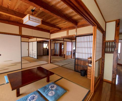 Ōbeにある忠大　の木製の天井とテーブル付きのリビングルーム