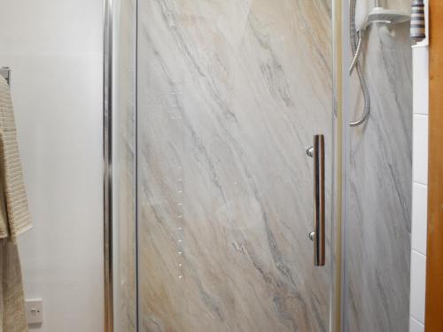 a shower with a glass door in a bathroom at Bayview in Kentallen