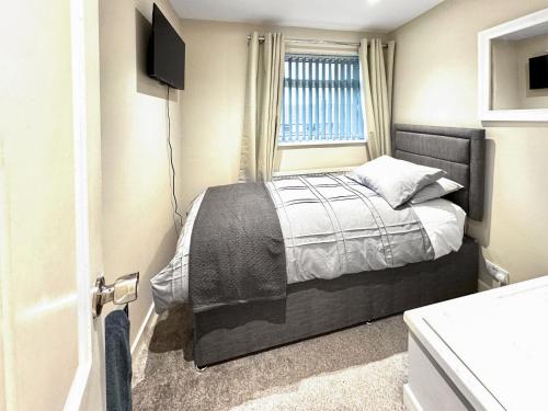 ein kleines Schlafzimmer mit einem Bett und einem Fenster in der Unterkunft Larch Cottage in Barrow in Furness