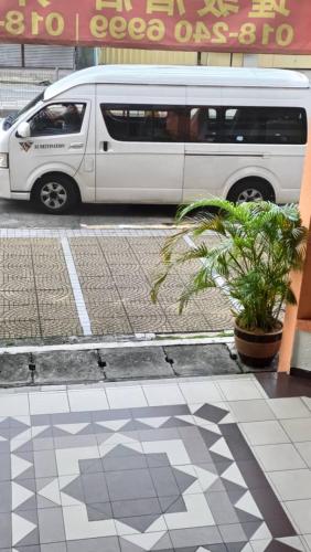 a white van parked on a street with a plant at hotel bintang in Kuala Lumpur