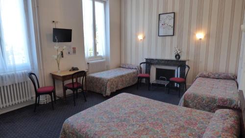 a hotel room with two beds and a fireplace at Hôtel Saint Jean in Vals-les-Bains