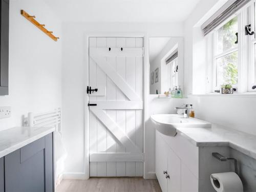 a white bathroom with a sliding barn door at East View in Langton Matravers