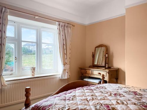 a bedroom with a bed and a mirror and a window at River View in Youlgreave