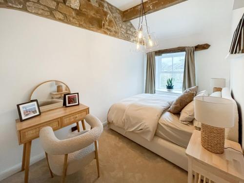 um quarto com uma cama, uma secretária e um espelho em Middle Cottage em Middlesmoor
