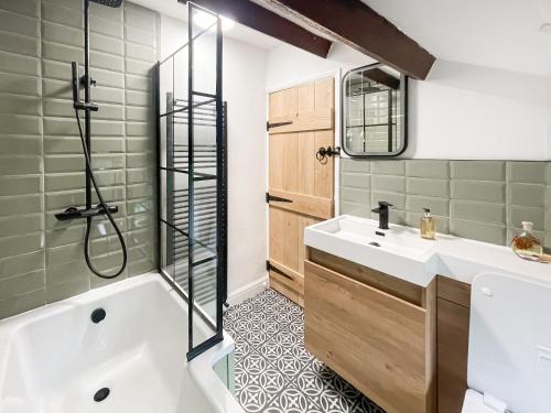uma casa de banho com uma banheira, um lavatório e um chuveiro em Middle Cottage em Middlesmoor