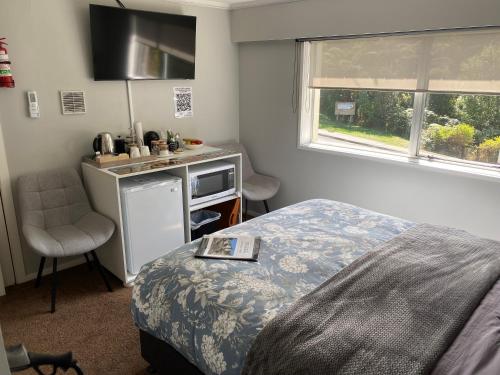 a bedroom with a bed and a kitchen with a sink at BBs B&B in Lower Hutt