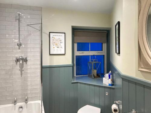 a bathroom with a shower and a toilet and a window at Family Retreat in Grassington