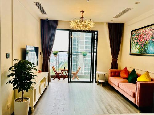 sala de estar con sofá y lámpara de araña en Xjng Homes - Ocean Park, en Hanói